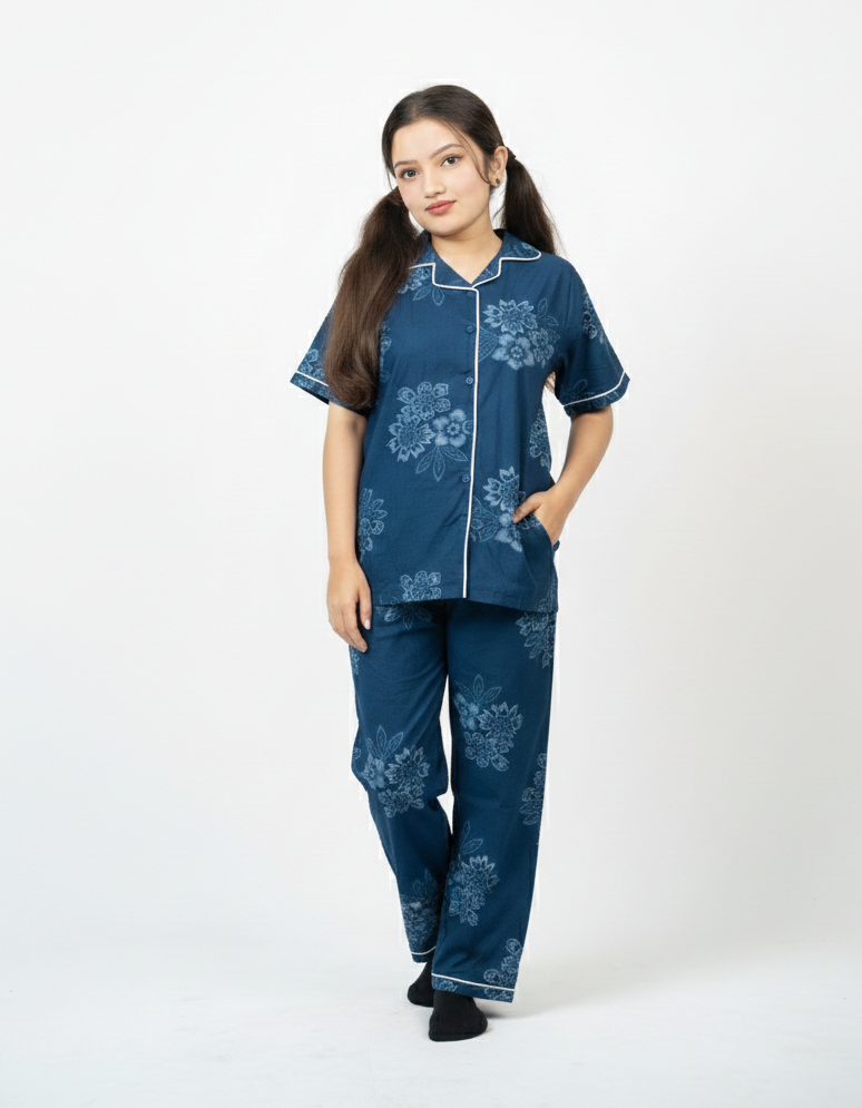 Woman wearing a blue pajama set with floral patterns on a white background